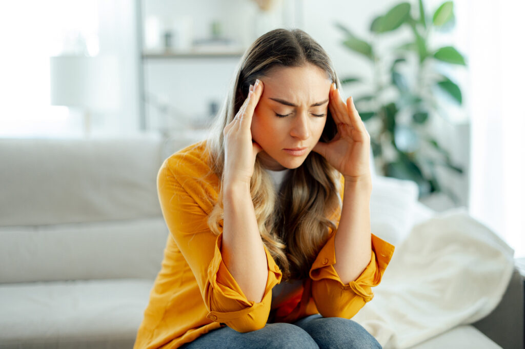 Woman holding her head due to allergy symptoms in Poway, CA